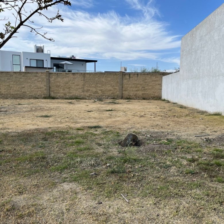 Imagen del terreno en venta con cielo azul y entorno despejado en Residencial Mayorca, León.