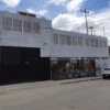 fachada de bodega edificio gris con murales artísticos.