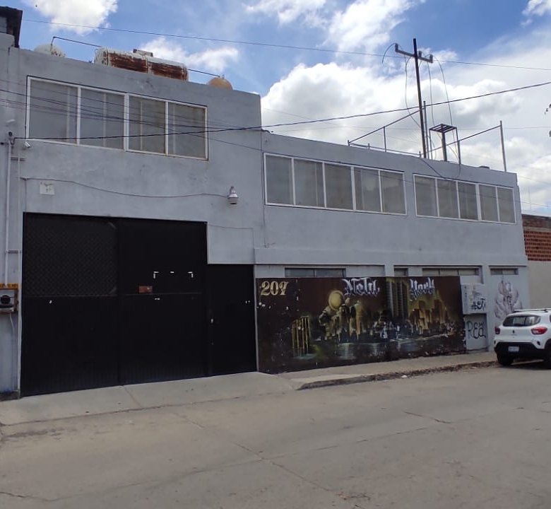 fachada de bodega Edificio gris con murales artísticos.