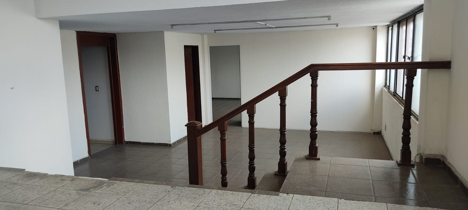 Espacio interior con escaleras y ventanas.