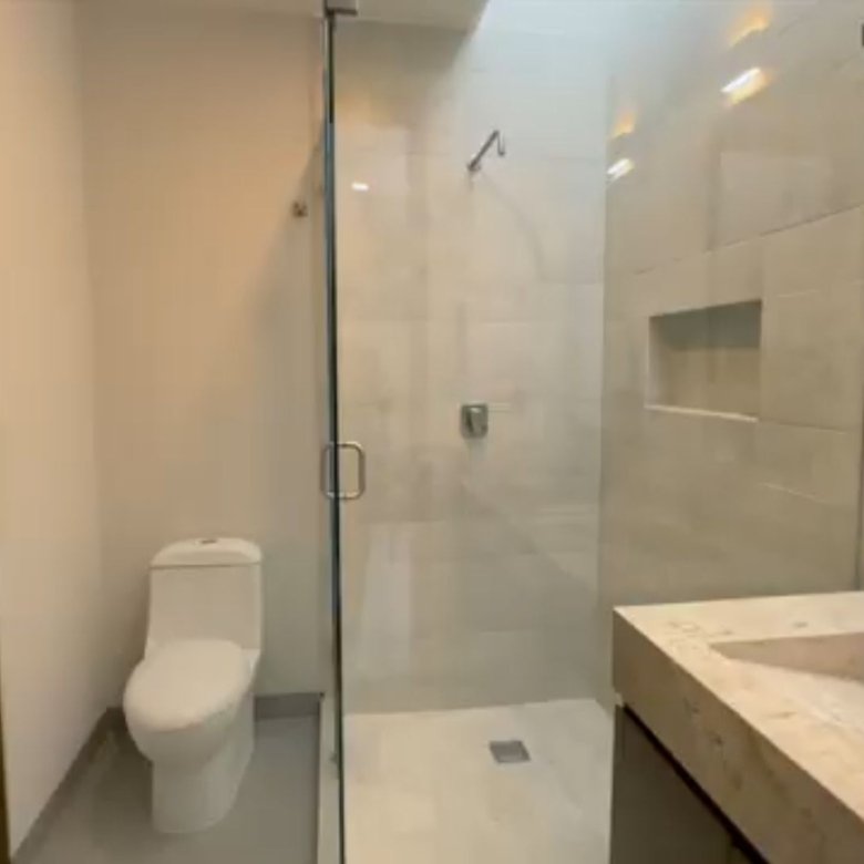 Baño moderno con ducha y lavabo.