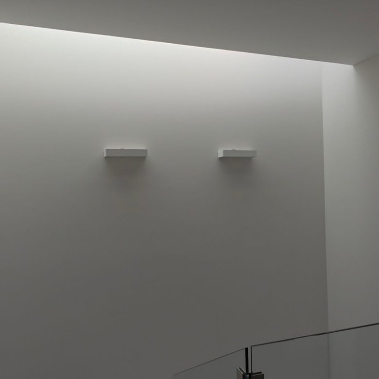 Pared blanca con iluminación suave.