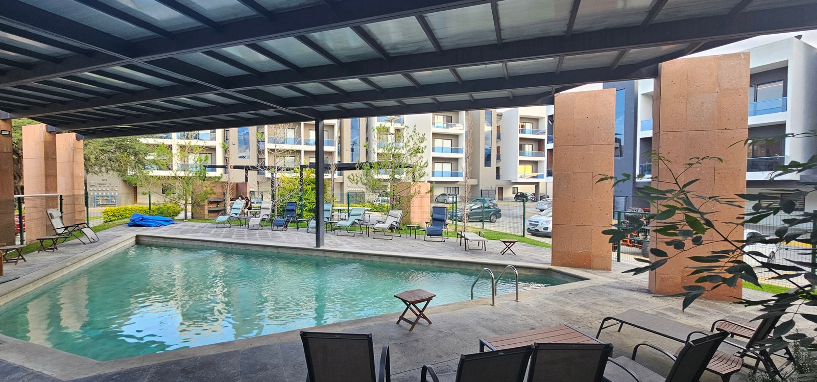 Piscina tranquila en complejo residencial Rubí con ambiente relajante.