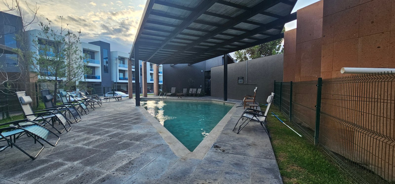 Piscina tranquila en complejo residencial Rubí con ambiente relajante.