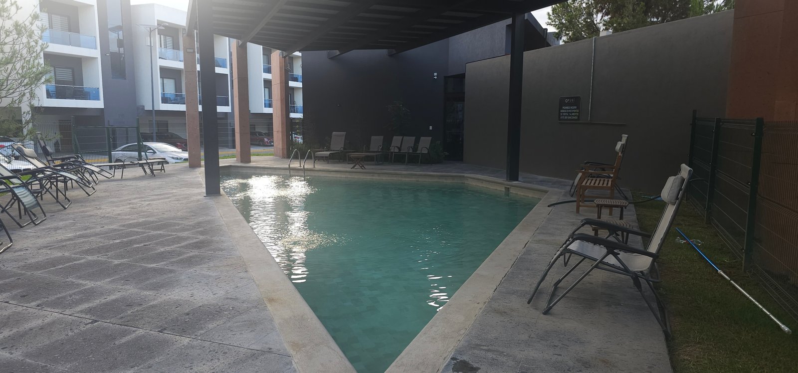 Piscina tranquila en complejo residencial Rubí con ambiente relajante.