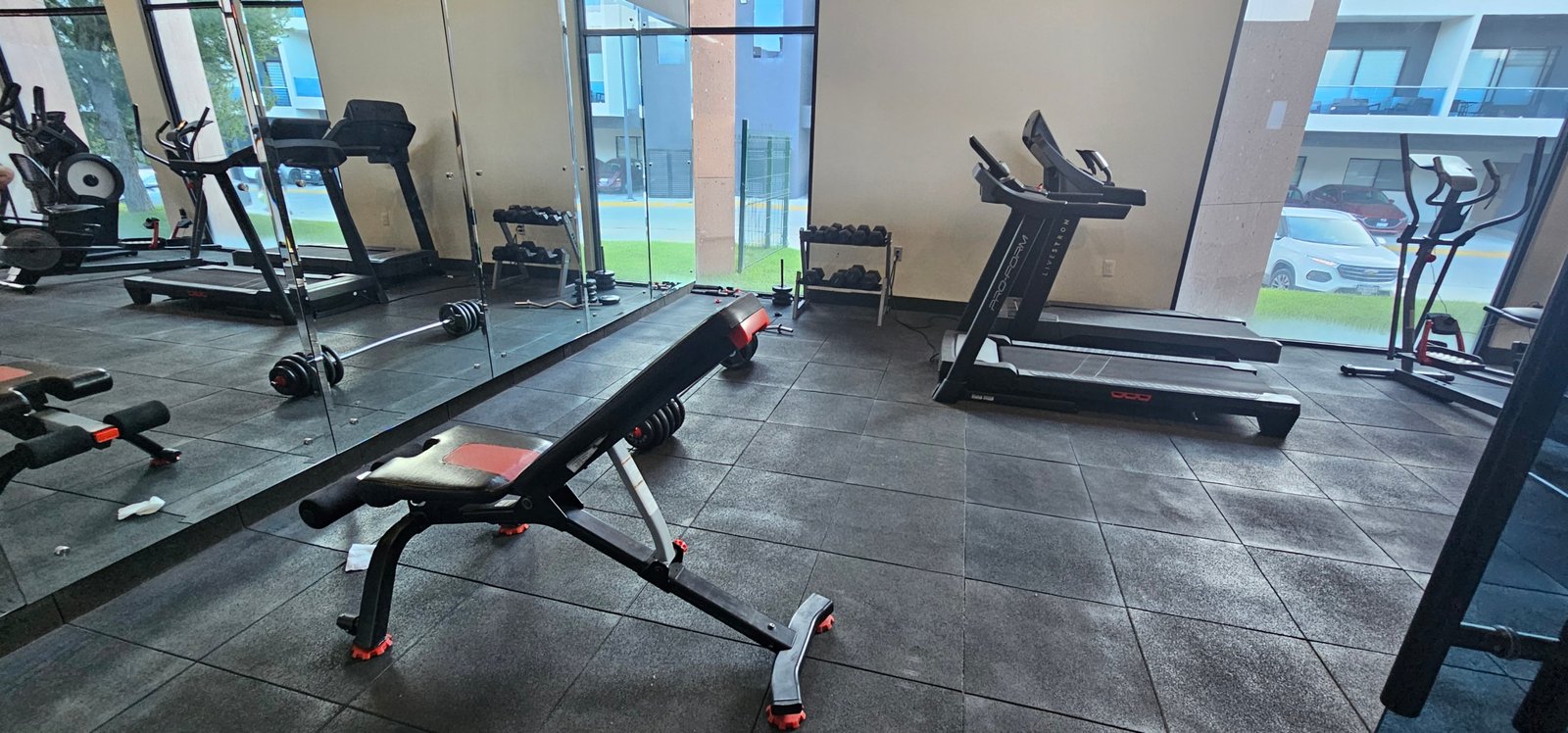 Gimnasio con máquinas de ejercicio en Residencial Rubí, ideal para entrenamiento físico.