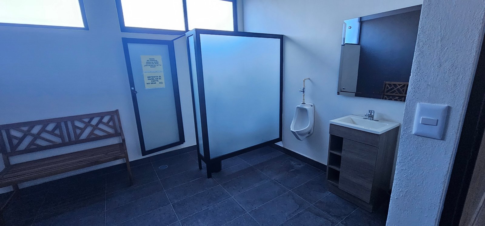Baño moderno con lavabo y urinario dentro del área del gimnasio en Residencial Rubí, León Gto.