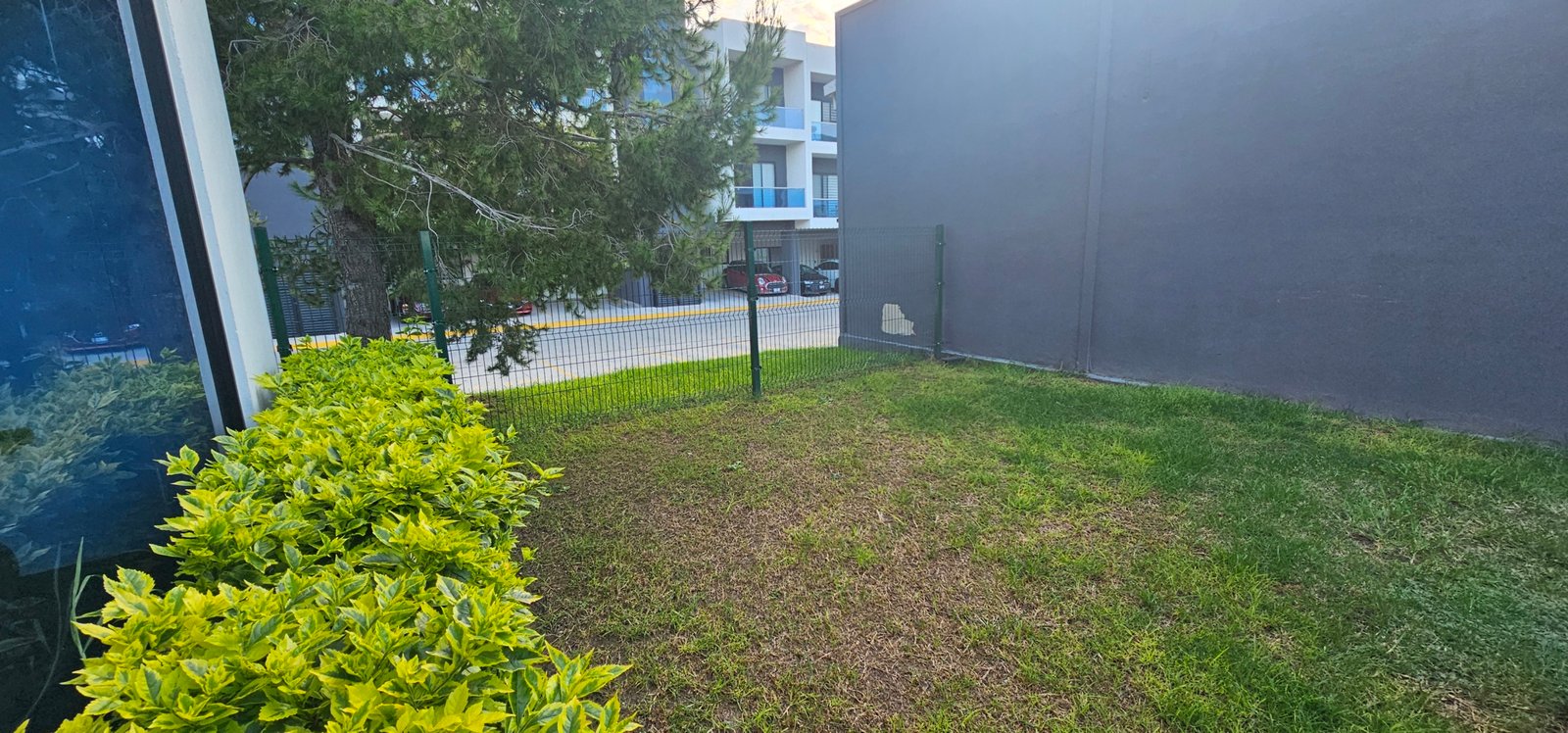 Jardín con plantas decorativas y edificios cercanos dentro del desarrollo Residencial Rubí en León, Gto.