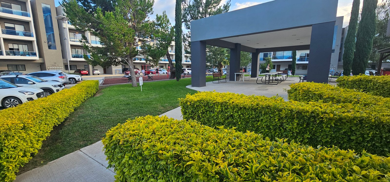 Jardín con áreas verdes y edificios residenciales en León, Gto.