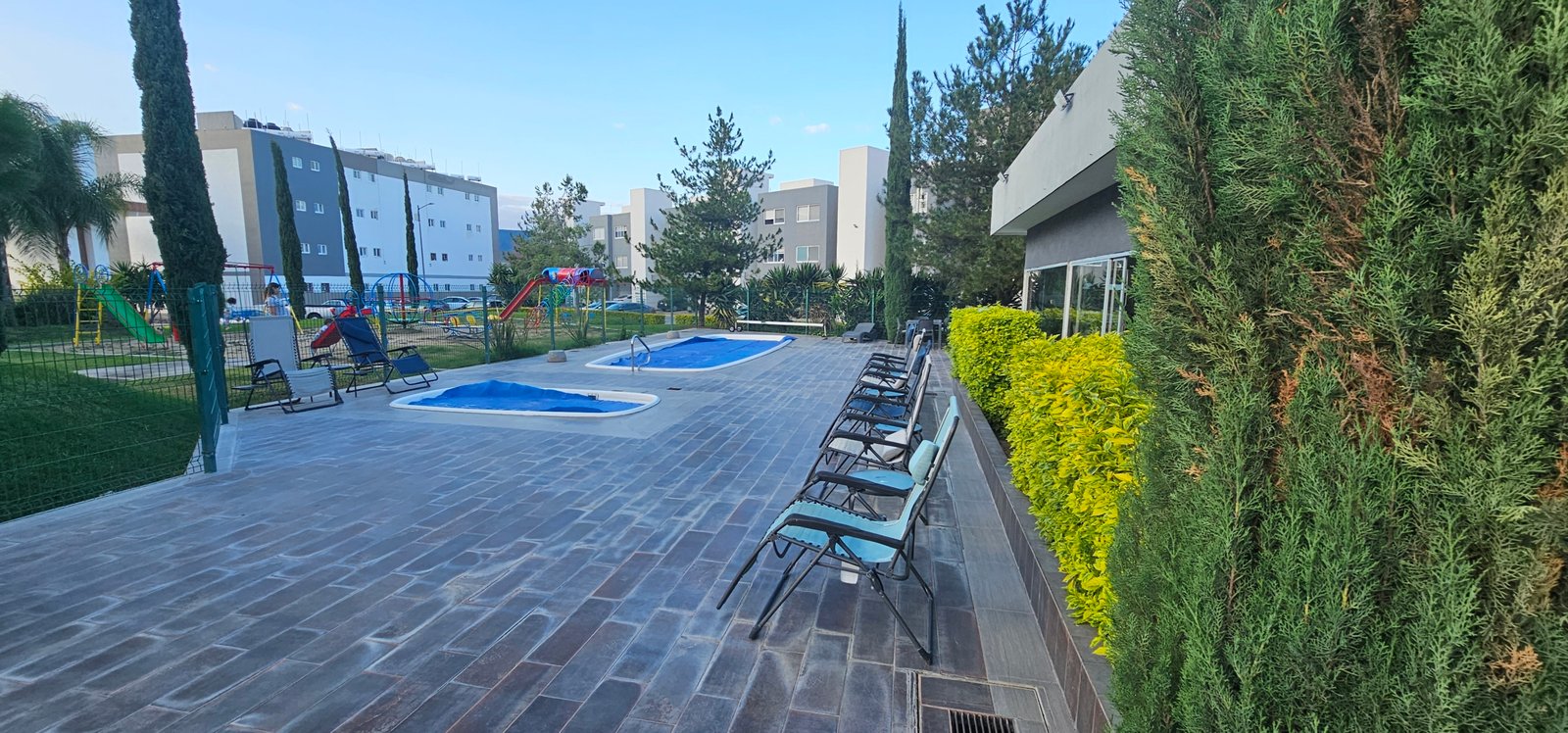 Área recreativa con piscinas y jardines en Residencial Rubí, León Guanajuato