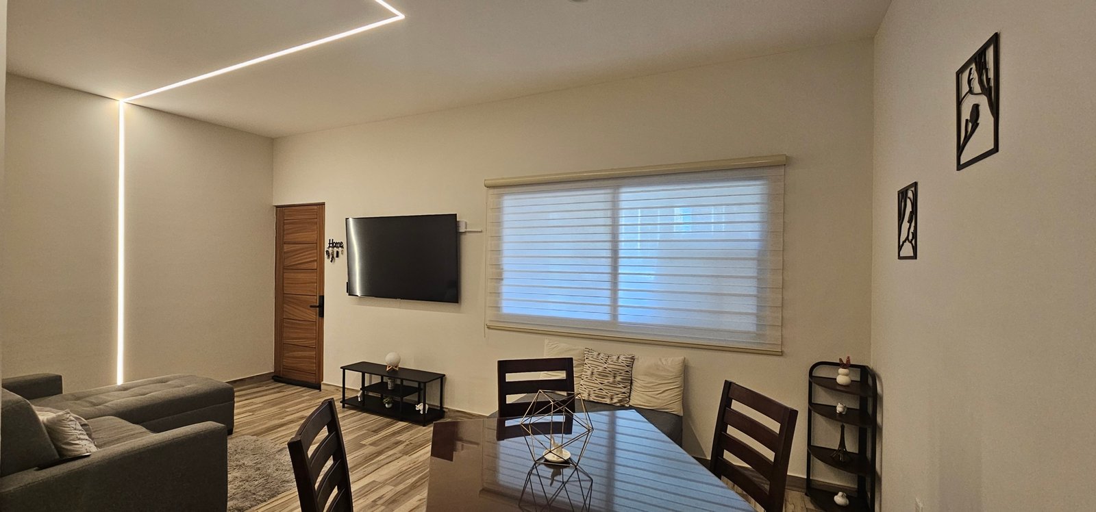 Sala moderna con muebles elegantes y luz ambiental suave.