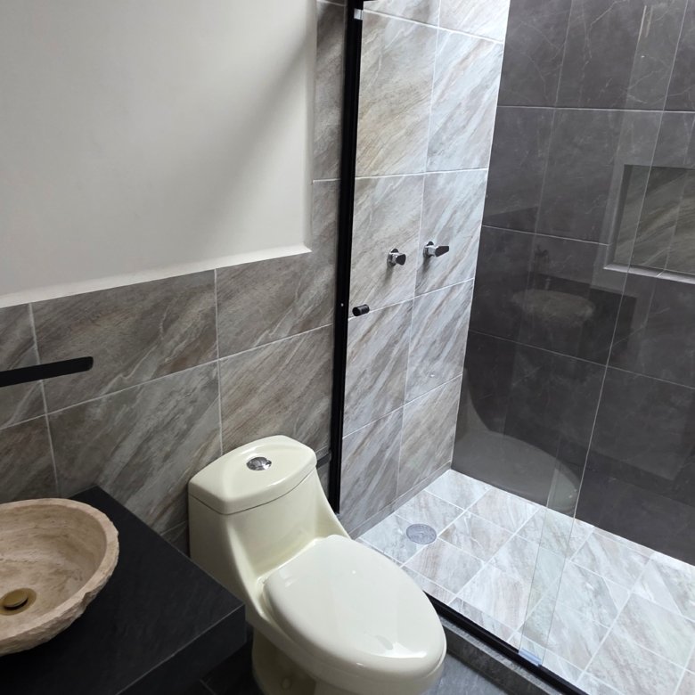 Baño moderno con ducha y lavabo.