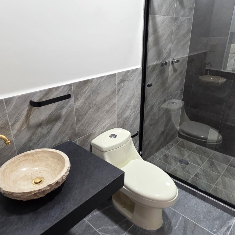 Baño moderno con ducha y lavabo.