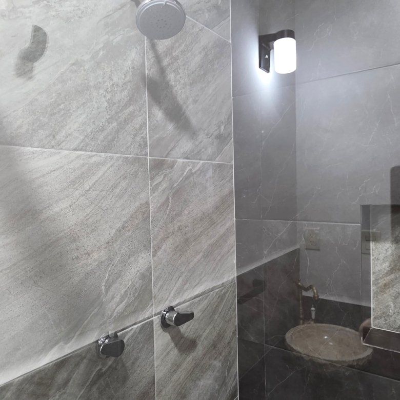 Baño moderno con ducha y lavabo.