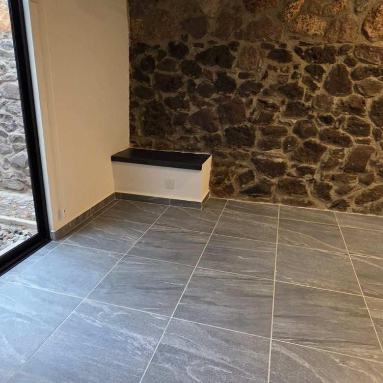 Sala con pared de piedra y azulejos