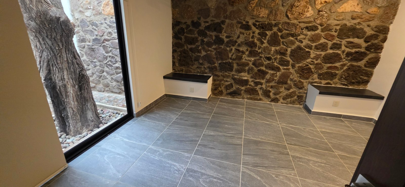 Sala con pared de piedra y azulejos