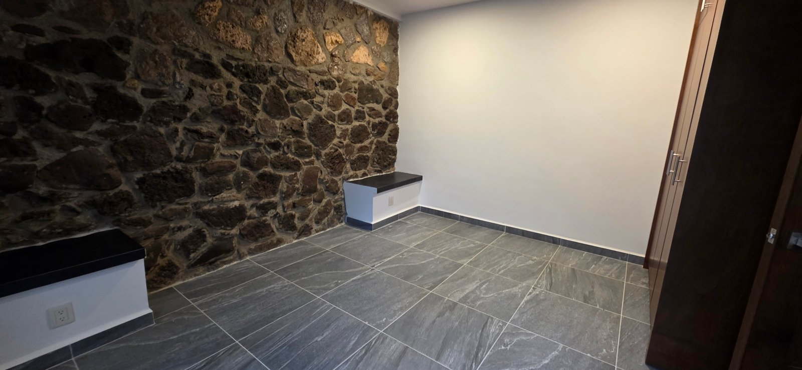 Habitación con pared de piedra desnuda