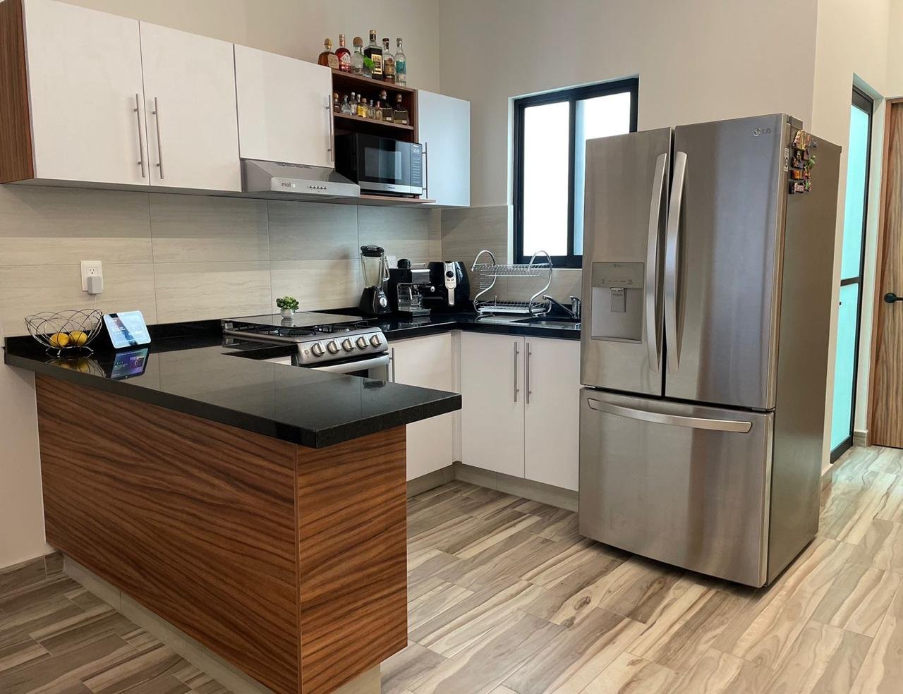 Cocina moderna con electrodomésticos elegantes en departamento amueblado en Residencial Rubí, León Guanajuato.