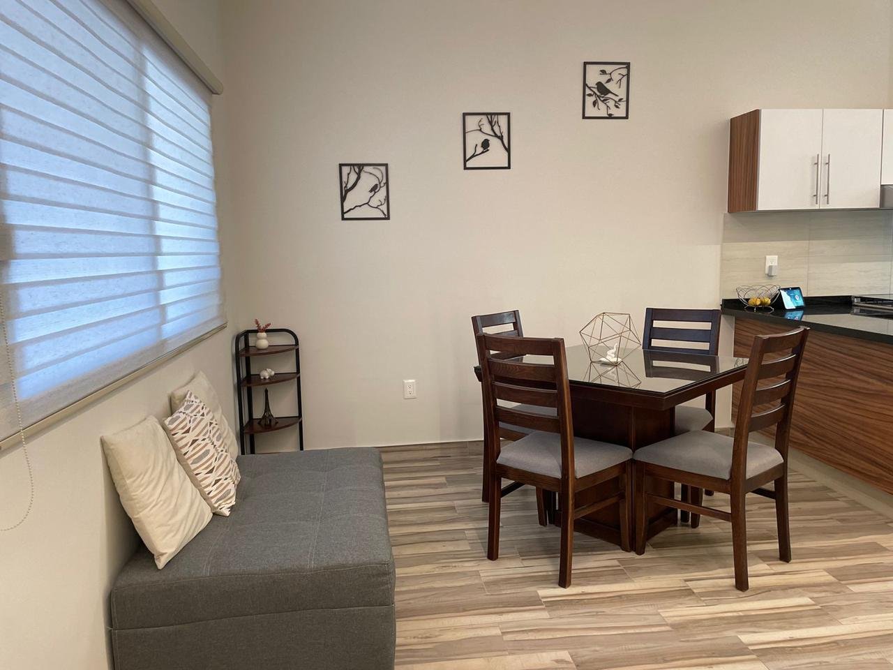 Sala con comedor moderno y ventanas grandes en departamento amueblado en Residencial Rubí León Gto