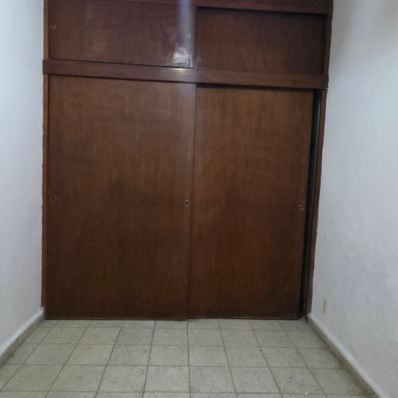 Habitación vacía con puertas de madera.