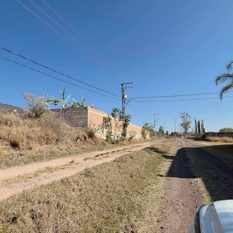 Camino rural con vegetación y edificios cerca de terreno en venta en Cañada de Negros, Purísima del Rincón, Guanajuato