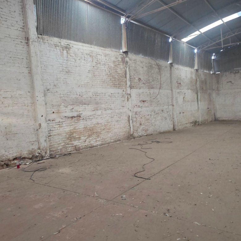 Vista del espacio interior de la bodega con muros de ladrillo y piso despejado listo para uso logístico en León Guanajuato.