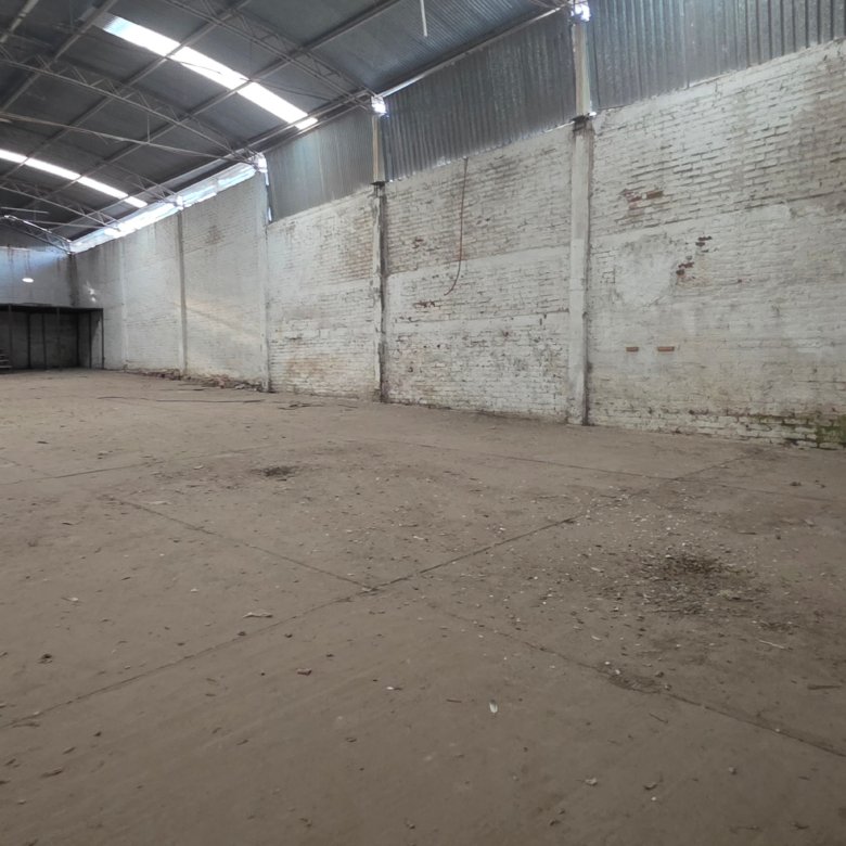 Interior de bodega en renta en Los Castillos León Gto con espacio vacío y paredes de ladrillo para almacenamiento industrial.