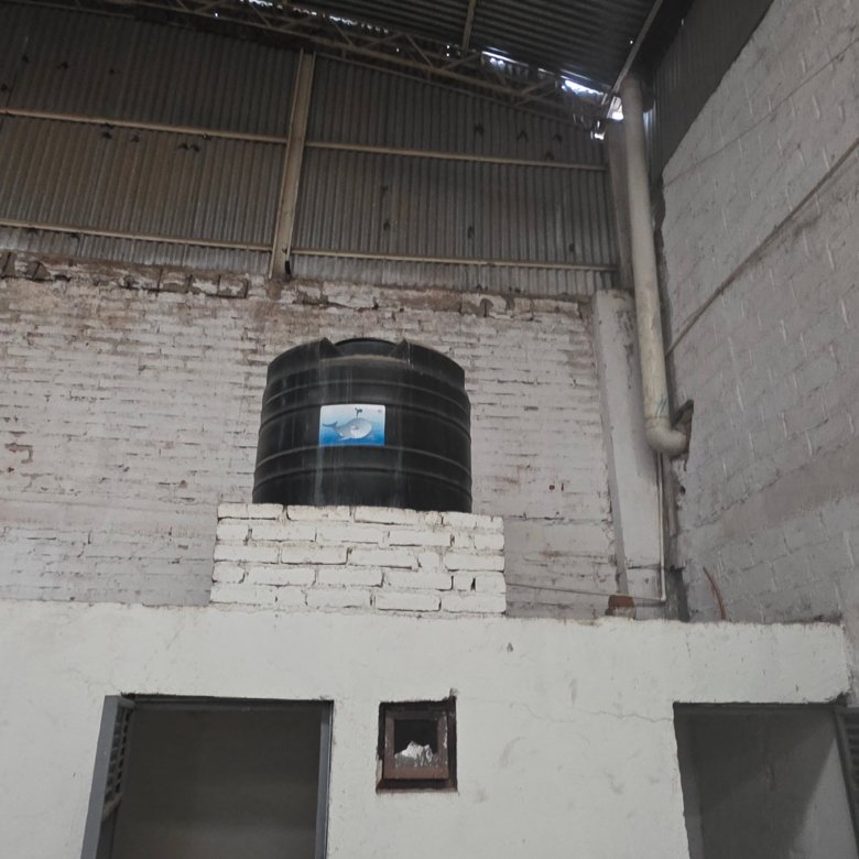 Tanque negro tinaco sobre pared blanca dentro de bodega en renta en Los Castillos León Guanajuato, espacio vacío de 700 m².