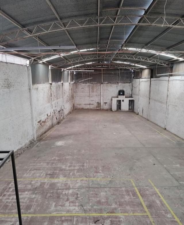 Interior de bodega en renta en Los Castillos León Guanajuato con espacio vacío y paredes de ladrillo para almacenamiento.