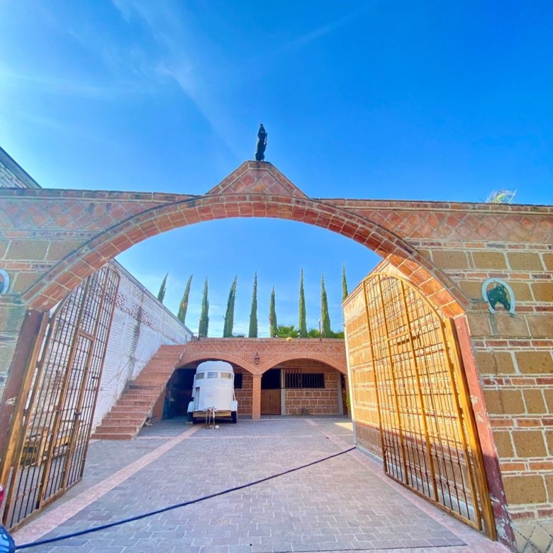 Entrada a patio con árboles en rancho hípico de lujo estilo hacienda en venta en San Francisco del Rincón Guanajuato
