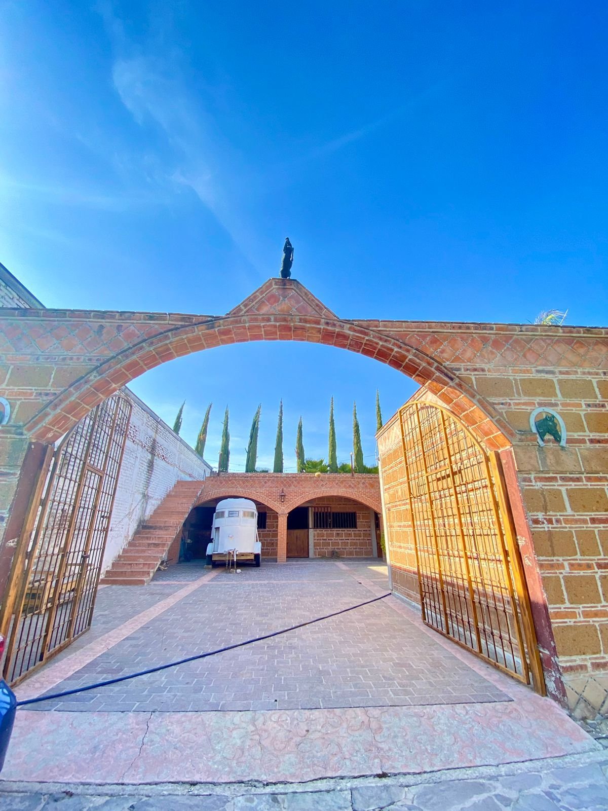 Entrada a patio con árboles en rancho hípico de lujo estilo hacienda en venta en San Francisco del Rincón Guanajuato