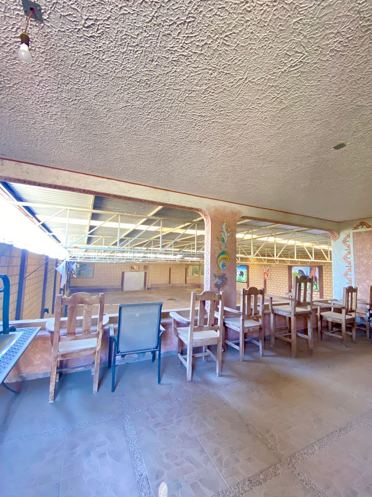 Sala amplia con mesas y sillas en rancho hípico en venta en San Francisco del Rincón ideal para eventos y convivencia