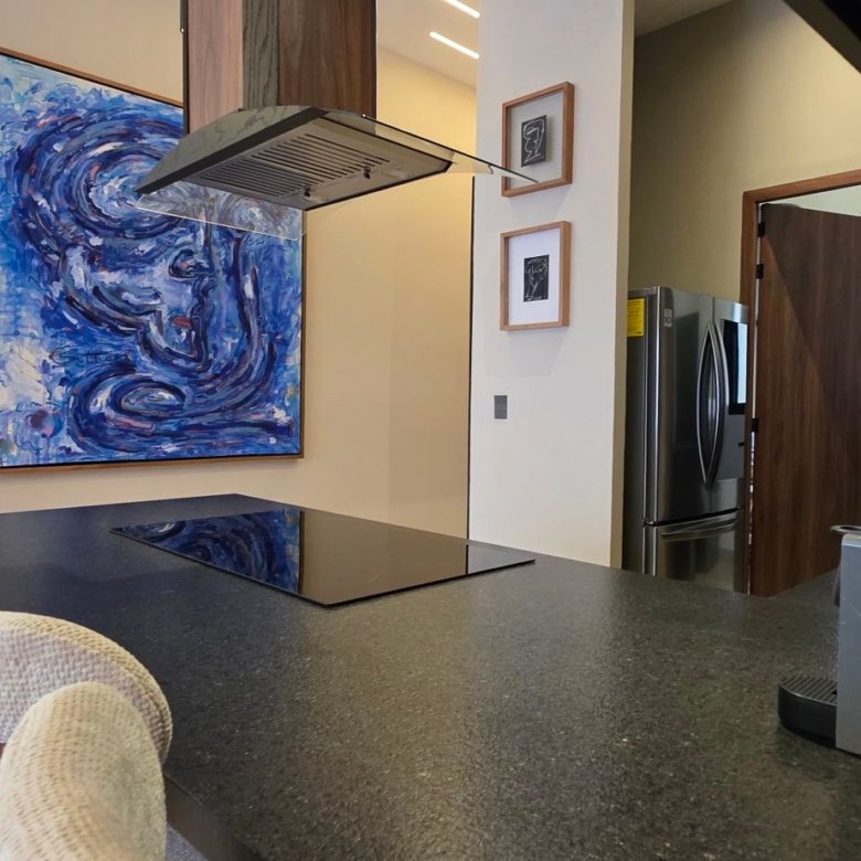 Cocina moderna equipada con acabados de lujo y decoración de arte abstracto en departamento de lujo en venta, zona norte, León, Guanajuato.