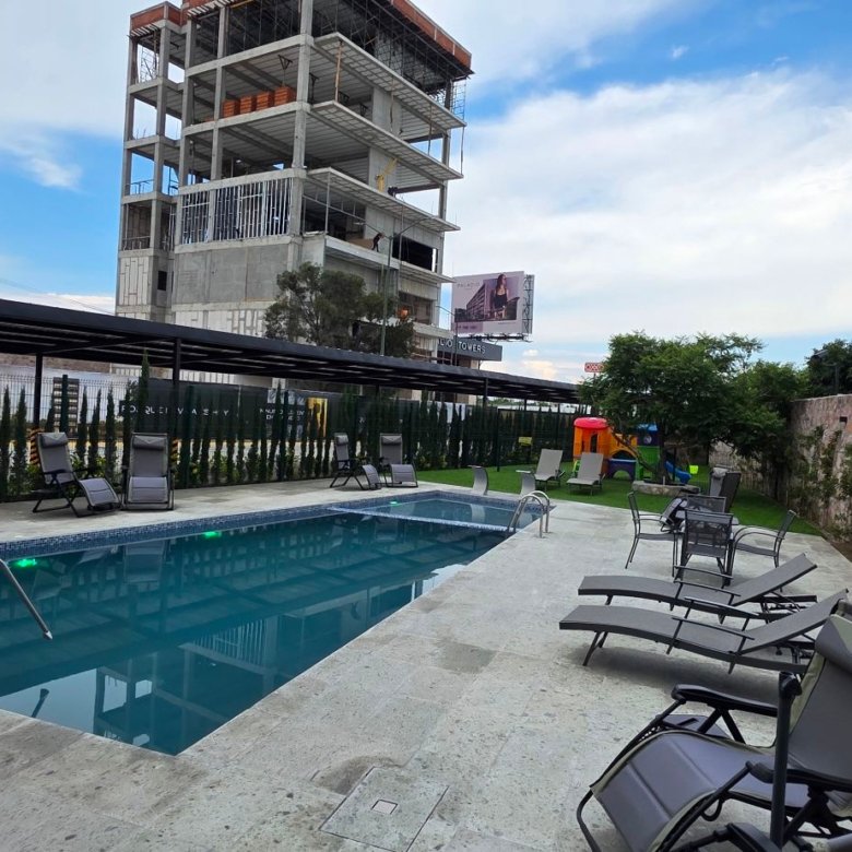 Alberca residencial y fachada de la torre de departamentos de lujo en venta, zona norte, León, Guanajuato.