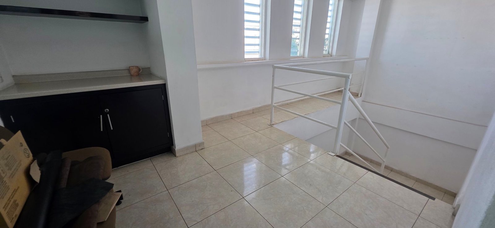 Pasillo de distribución con escaleras e iluminación natural por ventanas en tenería en venta o renta, Fraccionamiento Industrial Santa Crocce, León, Guanajuato.