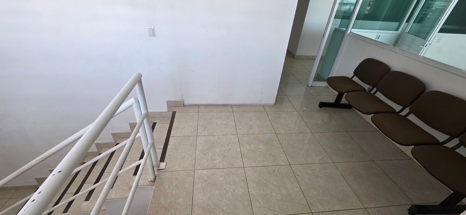 Área de recepción, sala de espera corporativa y escaleras a oficinas en tenería en venta o renta, Fraccionamiento Industrial Santa Crocce, León, Guanajuato.