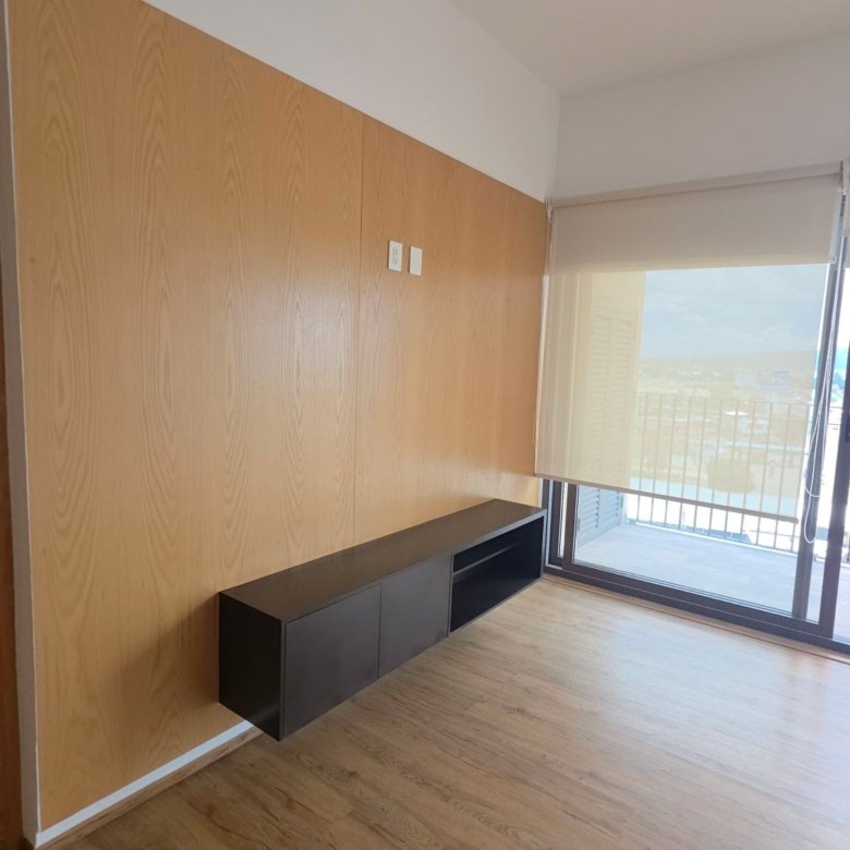 Sala moderna con muro de madera clara en departamento en renta Grand Valbuena León Modelo Berlín