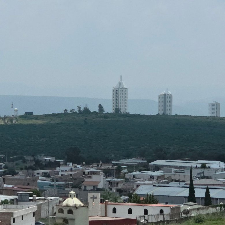Vista de edificios y entorno verde desde departamento en renta Grand Valbuena León Modelo Berlín