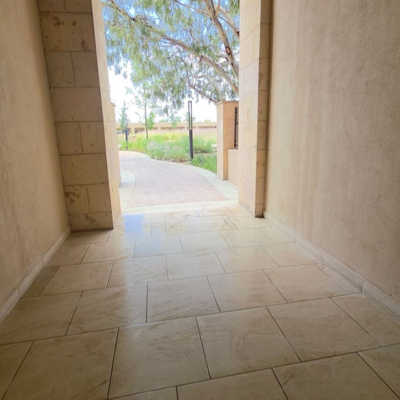 Pasillo con luz natural y vegetación en el residencial Grand Valbuena León
