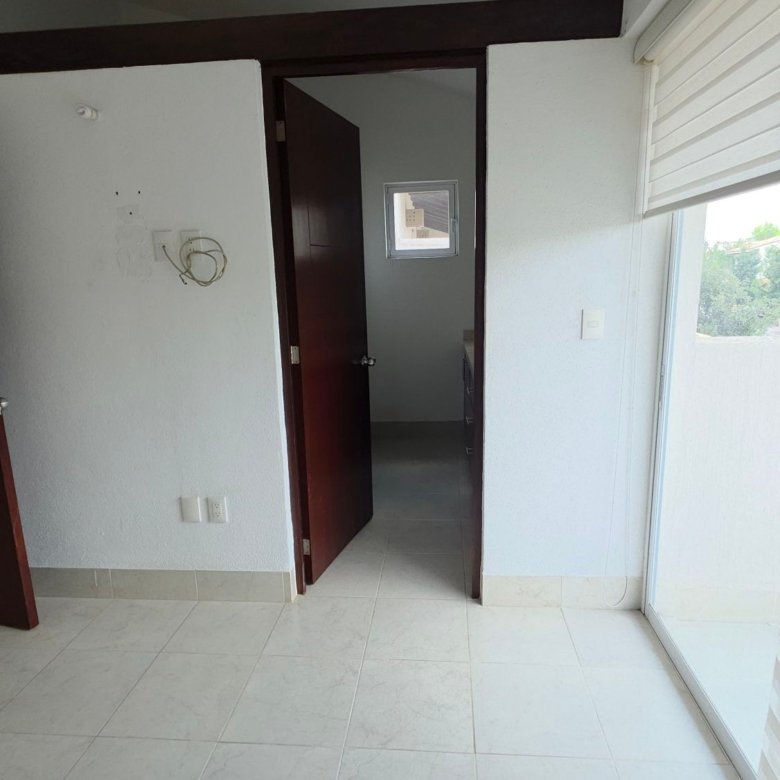 Recámara principal o secundaria iluminada con puerta y ventana en casa en renta en La Rioja, El Mayorazgo Residencial, León Gto.