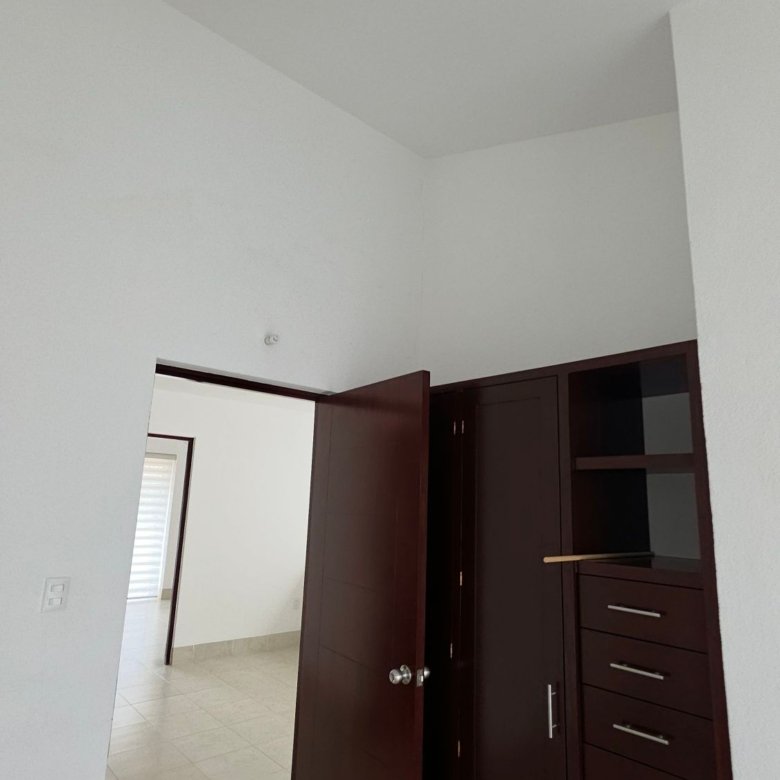 Recámara secundaria con clóset de madera oscura en renta en El Mayorazgo Residencial, León Gto
