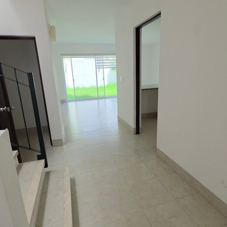 Pasillo interior con iluminación natural y vista al jardín en casa en renta, El Mayorazgo Residencial, León.