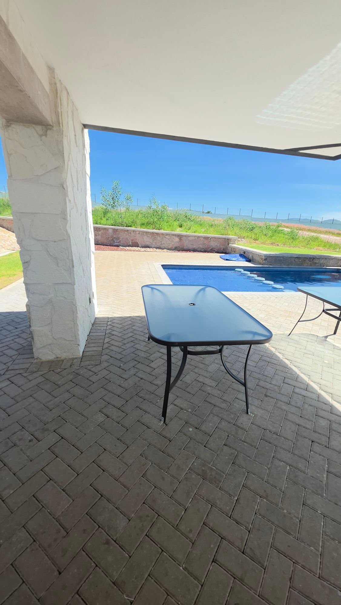 Terraza techada con mesa y vista a la alberca en Casa Club Ciudad Maderas Leon terreno en venta Huizache Torresa Inmobiliaria