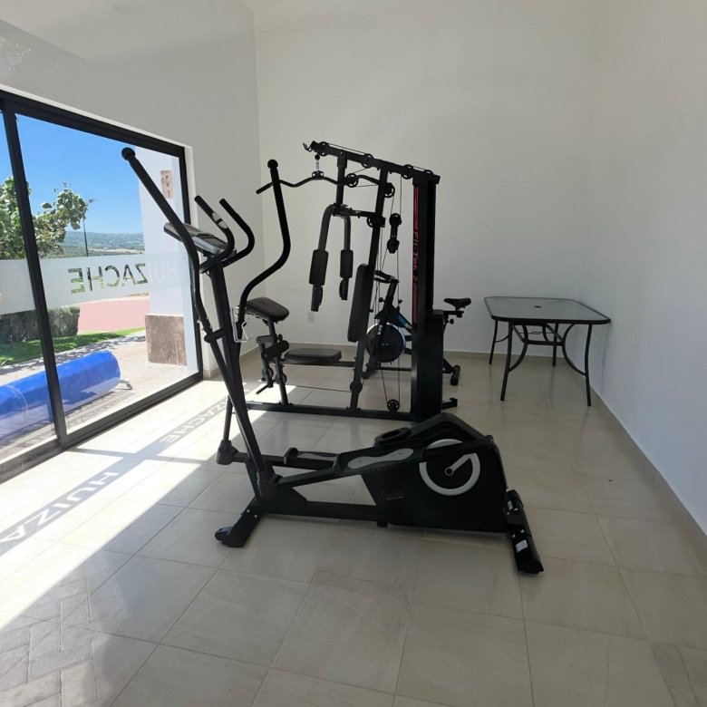 Vista interior del gimnasio con equipo de ejercicio en Casa Club Ciudad Maderas Leon terreno en venta Huizache torresa
