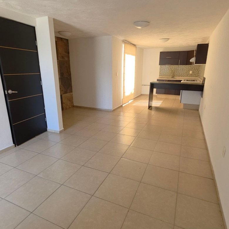 Estancia de sala comedor con luz natural y cocina integral al fondo en casa en renta Residencial Oasis Leon Gto