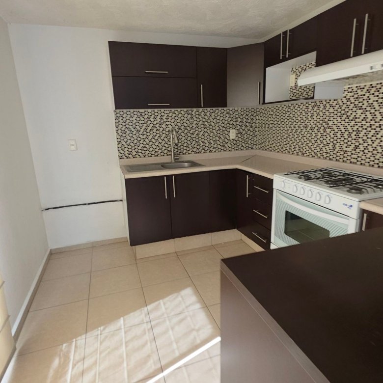 Vista angular de cocina integral en L con espacio para refrigerador en casa en renta Residencial Oasis Leon Gto