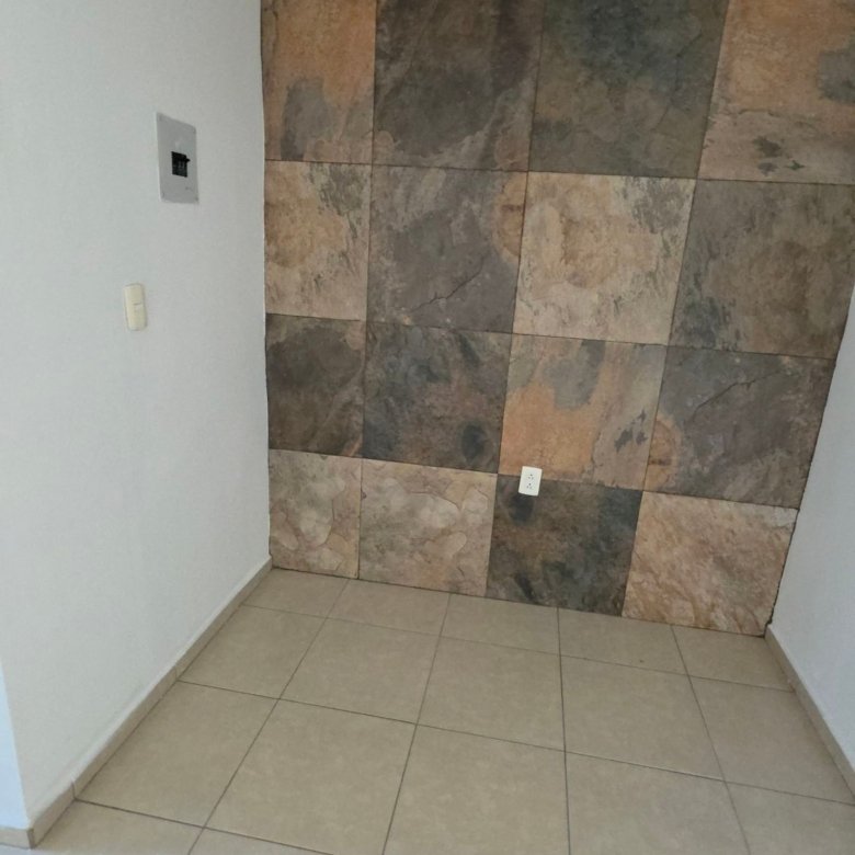Muro decorativo de acento con recubrimiento tipo piedra en sala comedor de casa en renta Residencial Oasis Leon Gto
