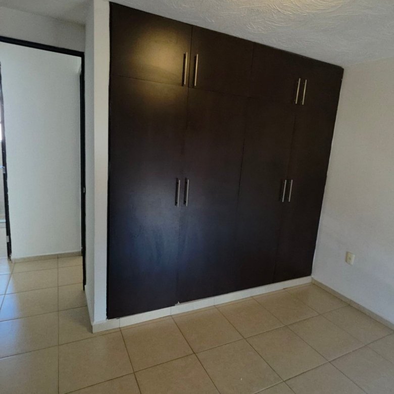 Closet de piso a techo de madera oscura en recamara de casa en renta Residencial Oasis Leon Gto