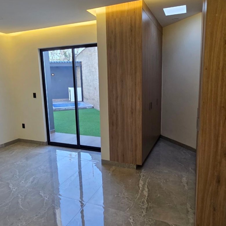 Sala moderna con acabados de lujo y vista al jardín en casa en venta El Mayorazgo La Gavia León Gto