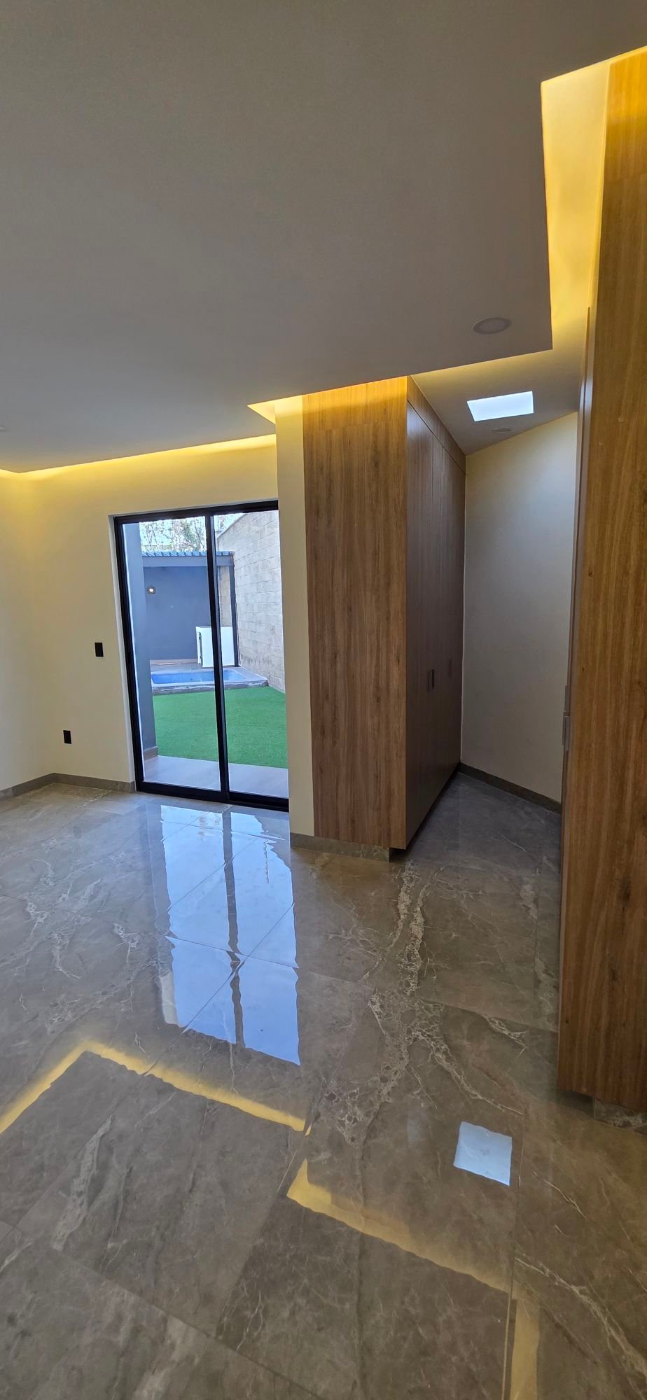 Sala moderna con acabados de lujo y vista al jardín en casa en venta El Mayorazgo La Gavia León Gto